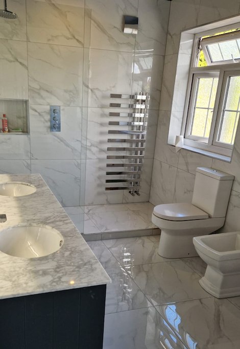 Marble bathroom with twin vanity by AG Signature Renovation