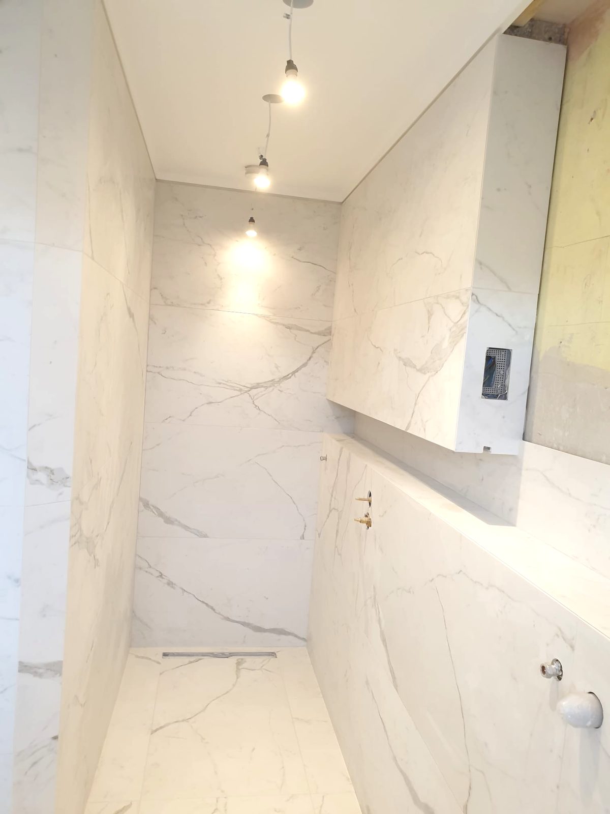 Marble wet room with rainfall shower by AG Signature Renovation