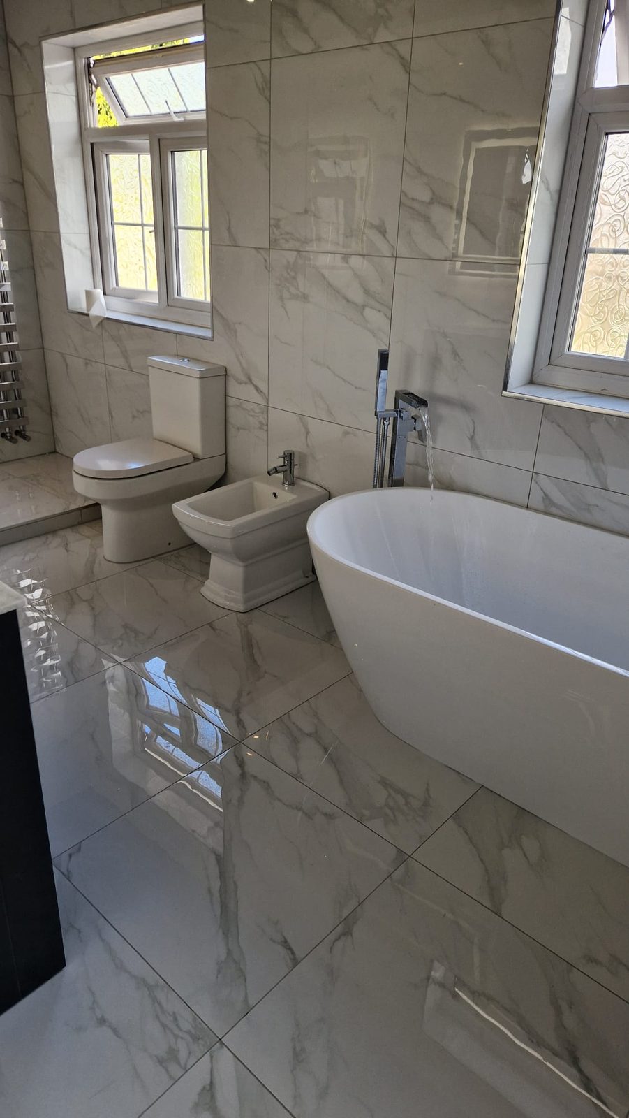 Marble bathroom with freestanding bath and floor-to-ceiling marble tiles
