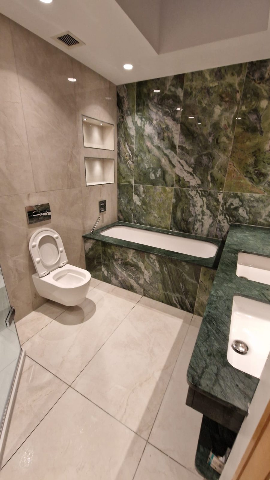 Green marble bathroom with wall-hung WC and basin